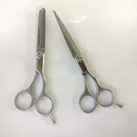 Три дрэтсабоферы сдвигают тонкие ножницы для волос.