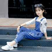 Cô gái denim bib mùa xuân và mùa thu mới bộ đồ trẻ em Hàn Quốc phù hợp với cậu bé lớn học sinh tiểu học - Quần jean
