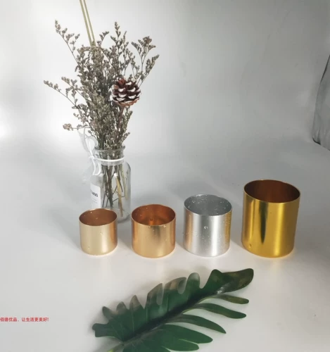 Свеча, бокал, металлическая чайная чашка, металлический стакан