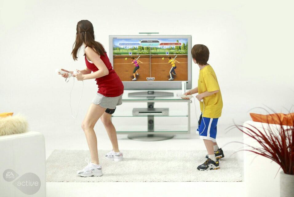 семья играет в теннис на приставке Nintendo Wii