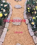Натуральный камень желтый маленький каменный двор украшает на садовой дорожке цветы.